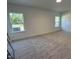 Bright bedroom with neutral carpet, two windows, and crisp white walls at 704 Compeer Way # 28, Rolesville, NC 27571