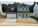 Two story home featuring blue siding, white trim, black roof, and an attached two car garage at 704 Compeer Way # 28, Rolesville, NC 27571