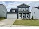 Two-story home with blue siding, white trim, a two-car garage and a well manicured front lawn at 704 Compeer Way # 28, Rolesville, NC 27571