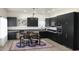 Modern kitchen with sleek dark cabinetry, stainless steel appliances, and decorative chandelier at 735 Alexander Ave, Henderson, NC 27536