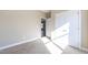 Bedroom with neutral carpet, base trim, double door closet, and doorway to another room at 818 E Holly St, Rocky Mount, NC 27801