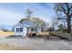 Quaint single-story home with a gravel driveway, a front porch, and a newly constructed wood fence at 818 E Holly St, Rocky Mount, NC 27801