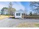 Charming single-story home features a gravel driveway, manicured lawn, and inviting front porch at 818 E Holly St, Rocky Mount, NC 27801
