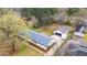 Aerial view of a single-story home, showcasing its backyard, driveway, detached garage, landscaping, and neighborhood at 928 Hanford Rd, Graham, NC 27253