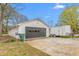 View of the detached garage with a gray door and a trailer next to it at 928 Hanford Rd, Graham, NC 27253