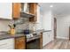 Modern kitchen featuring stainless steel appliances, granite countertops, and a mix of white and wood cabinetry at 928 Hanford Rd, Graham, NC 27253