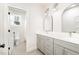 Modern bathroom with double sinks, gray cabinets, arched mirrors, and a separate toilet room at 100 High Ridge Ln, Pittsboro, NC 27312