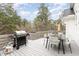 Outdoor deck with a grill, dining table, and a view of the surrounding wooded landscape at 100 High Ridge Ln, Pittsboro, NC 27312