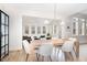 Bright dining room features a modern chandelier and view into the sunroom through an open doorway at 100 High Ridge Ln, Pittsboro, NC 27312