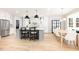 Bright, modern kitchen with stainless steel appliances, a large island with seating, and an open dining area at 100 High Ridge Ln, Pittsboro, NC 27312