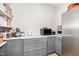 Walk-in pantry with gray cabinets, granite countertop and stainless refrigerator at 100 High Ridge Ln, Pittsboro, NC 27312