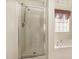 Bright bathroom featuring glass enclosed shower and soaking tub beneath a window at 1009 Limeberry Ct, Clayton, NC 27520