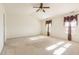 Spacious bedroom featuring a ceiling fan and bright natural light from the curtained windows at 1009 Limeberry Ct, Clayton, NC 27520