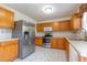 Kitchen featuring stainless appliances, tile backsplash, and wooden cabinets at 1009 Limeberry Ct, Clayton, NC 27520