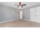 Empty bedroom with neutral carpet, gray walls, a ceiling fan, and a closet at 101 Lager Ln, Garner, NC 27529