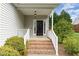 Inviting front porch features brick steps and white railings leading to a classic black front door at 101 Lager Ln, Garner, NC 27529