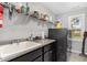 Functional laundry room with sleek, dark cabinets, a white utility sink, and modern appliances at 101 Lager Ln, Garner, NC 27529
