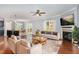 Bright living room featuring a fireplace, hardwood floors, ceiling fan, and an open floor plan with access to the kitchen at 101 Lager Ln, Garner, NC 27529