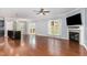 Sun-drenched living room with fireplace, ceiling fan, hardwood floors, and views of the kitchen and back patio at 101 Lager Ln, Garner, NC 27529