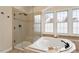 Bright bathroom features a glass enclosed shower, soaking tub, and a window bringing in lots of natural light at 101 Redfoot Run Rd, Chapel Hill, NC 27516