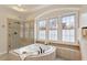 Bright bathroom features a soaking tub with tile surround and a large window that brings in natural light at 101 Redfoot Run Rd, Chapel Hill, NC 27516