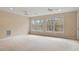 Sunlit bedroom boasting neutral carpet, twin ceiling fans, and large windows with outdoor views at 101 Redfoot Run Rd, Chapel Hill, NC 27516