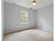 Light-filled bedroom with plush carpeting, ceiling fan, and a large window with natural light at 101 Redfoot Run Rd, Chapel Hill, NC 27516