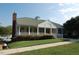 Community clubhouse featuring a wraparound porch, green roof, and manicured landscaping at 101 Redfoot Run Rd, Chapel Hill, NC 27516
