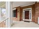 Inviting front porch featuring brick facade, white columns, and a dark brown front door at 101 Redfoot Run Rd, Chapel Hill, NC 27516