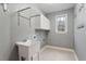 Functional laundry room with white cabinets, sink, and window, blending utility with practicality at 101 Redfoot Run Rd, Chapel Hill, NC 27516