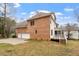 Side view of the home showing a two-car garage, back deck, and brick facade at 101 Redfoot Run Rd, Chapel Hill, NC 27516