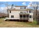 View of the back of a tan two-story home with a screened porch and deck, as seen from the backyard at 101 Redfoot Run Rd, Chapel Hill, NC 27516