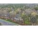 Serene aerial view of a beautiful home nestled amongst the trees, near a quiet road, and other homes at 104 Sierra Dr, Chapel Hill, NC 27514