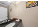 Compact bathroom featuring an oval mirror, granite countertop, and decorative artwork at 104 Sierra Dr, Chapel Hill, NC 27514