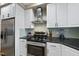 Modern kitchen featuring stainless steel appliances, granite countertops, and sleek white cabinetry at 104 Sierra Dr, Chapel Hill, NC 27514