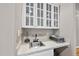 This wet bar features white cabinets, a sink, countertop space, and glass door cabinets, offering convenience and style at 104 Sierra Dr, Chapel Hill, NC 27514