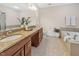 A spacious bathroom features double sinks, granite countertops, a soaking tub, and neutral tile at 10411 Rosegate Ct # 304, Raleigh, NC 27617