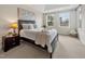 A cozy bedroom features natural light from two windows and neutral tones throughout the space at 10411 Rosegate Ct # 304, Raleigh, NC 27617