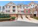 Attractive townhome featuring tan siding, red shutters, brick accents, and an attached garage at 10411 Rosegate Ct # 304, Raleigh, NC 27617