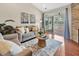 Bright living room featuring hardwood floors, a comfortable sofa, and sliding glass doors to the balcony at 10411 Rosegate Ct # 304, Raleigh, NC 27617