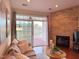 Living room with hardwood floors, stone fireplace, and sliding doors leading to a balcony overlooking a pond at 10411 Rosegate Ct # 304, Raleigh, NC 27617