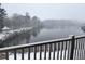 Scenic view of a tranquil pond during a gentle snowfall, framed by bare trees and a distant gazebo at 10411 Rosegate Ct # 304, Raleigh, NC 27617
