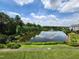 Overlooking a serene pond with lush trees and landscaping, under a beautiful blue sky at 10411 Rosegate Ct # 304, Raleigh, NC 27617