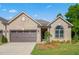 Inviting brick home featuring an attached garage and a manicured lawn at 1053 Beechcraft Dr # 124, Mebane, NC 27302