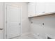 Well-lit laundry room with white cabinets and marble-look tile flooring provides both style and function at 1053 Beechcraft Dr # 124, Mebane, NC 27302