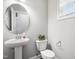 Stylish powder room with a pedestal sink, round mirror, and decorative accents at 109 Belle Plain Dr, Morrisville, NC 27560