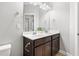 Bathroom with a dark wood dual vanity and a large mirror, illuminated by overhead lighting at 109 Belle Plain Dr, Morrisville, NC 27560