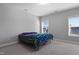 Simple bedroom with neutral walls and carpet, a bed with colorful bedding, and natural light from two windows at 109 Belle Plain Dr, Morrisville, NC 27560