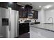 Modern kitchen features dark wood cabinets, granite countertops, stainless steel appliances, and stylish backsplash at 109 Belle Plain Dr, Morrisville, NC 27560
