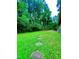 Expansive backyard featuring lush green grass, a stone pathway, and mature trees, perfect for outdoor activities at 1115 Park Ave, Henderson, NC 27536